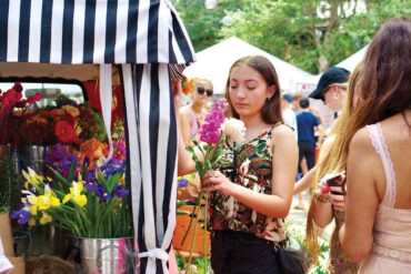 a person holding flowers at a market