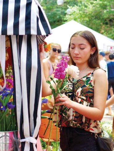a person holding flowers at a market